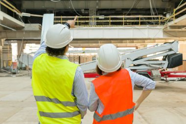 İnşaat bölgesinde adam mühendisi ve kadın mimarı. Bina, geliştirme, ekip çalışması ve insan konsepti