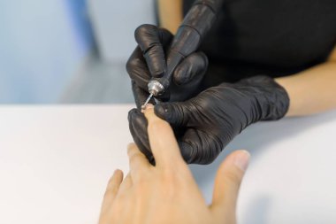 Profesyonel manikür closeup süreci. Siyah eldiven manikürcü kadın eller profesyonel araçları kullanarak manikür yapma. Güzellik salonunda tırnak ve El Bakımı