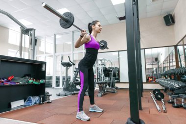 Makinelerde modern spor salonunda egzersiz genç atletik kadın. Fitness, spor, eğitim, insanlar, sağlıklı yaşam konsepti.