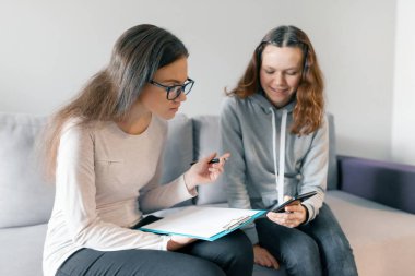 Genç kadın profesyonel psikoterapist ofisinde genç kız ile konuşurken. Ergenlik döneminde çocuk ruh sağlığı