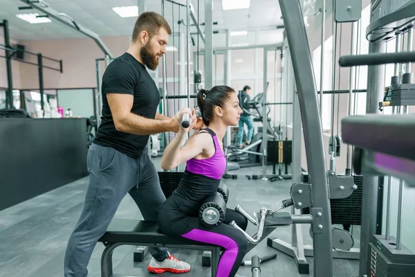 Osobisty trener fitness coaching i pomagając klient kobieta podejmowania ćwiczeń w siłowni. Sport, pracy zespołowej, szkolenia, koncepcja ludzie — Zdjęcie stockowe