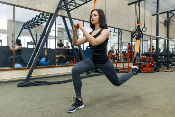 Genç fitness kadın spor salonunda askıları sistemini kullanarak egzersizleri yapıyor. Eğitim, spor, fitness, insanlar kavramı. — Stok fotoğraf