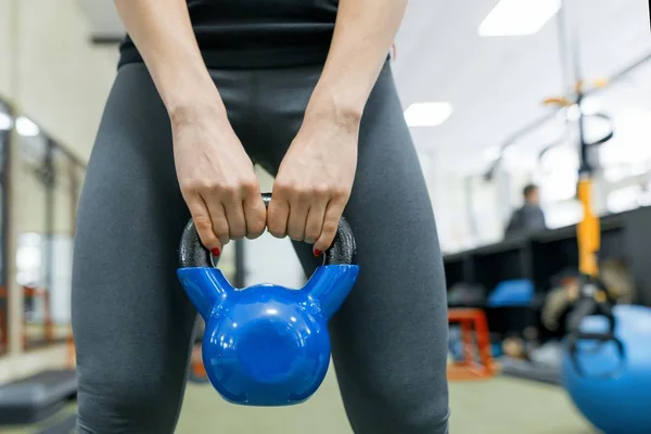 Primer plano de peso en manos de una joven deportista. Fitness, deporte, entrenamiento, personas, concepto de estilo de vida saludable . — Foto de Stock