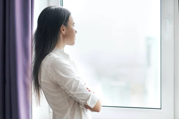 Porträt einer jungen selbstbewussten Geschäftsfrau in weißem Hemd mit verschränkten Armen, Frau blickt aus dem Fenster, Büro im Wolkenkratzer bewölkt, Kopierraum — Stockfoto