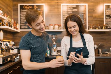 İki genç erkek ve kadın kahve dükkan sahipleri yakınındaki sayaç, konuşan ve gülen, kahve dükkanı iş kavramı