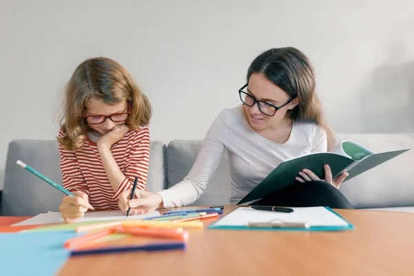 Fiatal tanárnőt, amely magán lecke gyerek, kislány ül asztalára írásban notebook — Stock Fotó