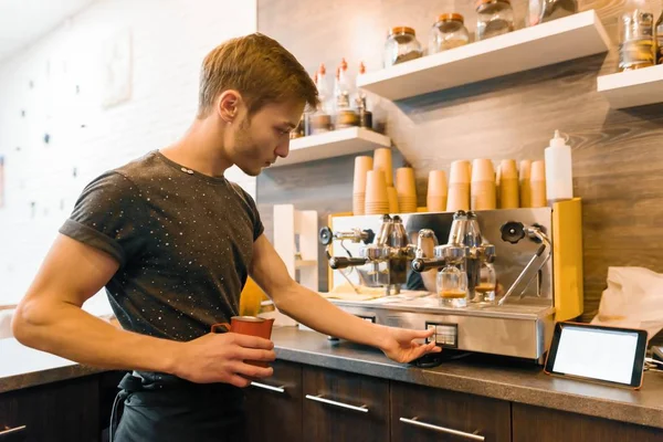 用机器做咖啡的年轻男性咖啡店工人 — 图库照片