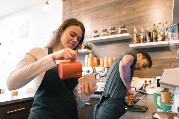 咖啡店工人年轻的微笑的男人和女人用机器煮咖啡, 专业的咖啡队咖啡馆业务 — 图库照片