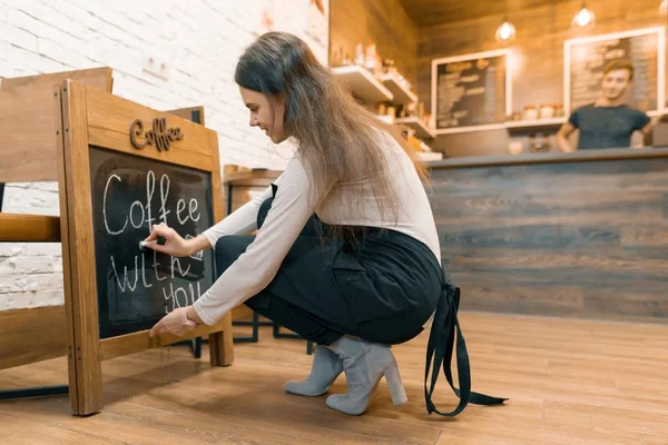 Il caffè con Lei, scrive in gesso su lavagna il proprietario femminile giovane della caffetteria . — Foto Stock