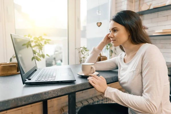 Jovem blogueira feminina em café com computador portátil e xícara de café fresco — Fotografia de Stock