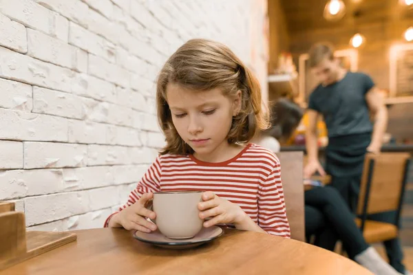 Bambina in caffè con grande tazza di bevanda artistica — Foto Stock