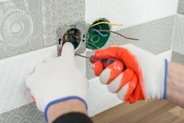 Felújítási és az építőipar, konyhában, részlete villanyszerelők kézi telepítése aljzat falon kerámia csempe, professzionális eszközökkel — Stock Fotó