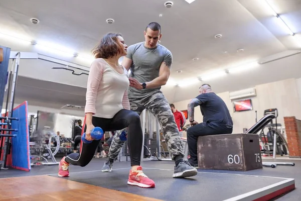 Persoonlijke fitness instructeur helpt zomer vrouw uitoefenen in de healthclub. Gezondheid fitness sport leeftijd concept — Stockfoto