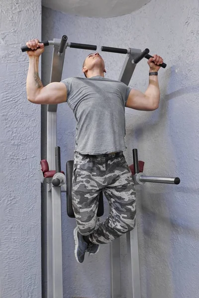 Junger kräftiger muskulöser Mann im Fitnessstudio, männliche Übungen, Klimmzüge machen — Stockfoto