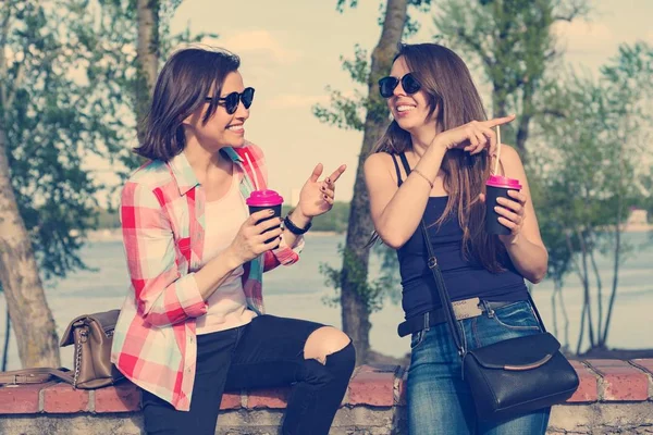 Happy two female friends drinking coffee and having fun. Background nature, park, river. Urban lifestyle and friendship concept — Stock Photo, Image