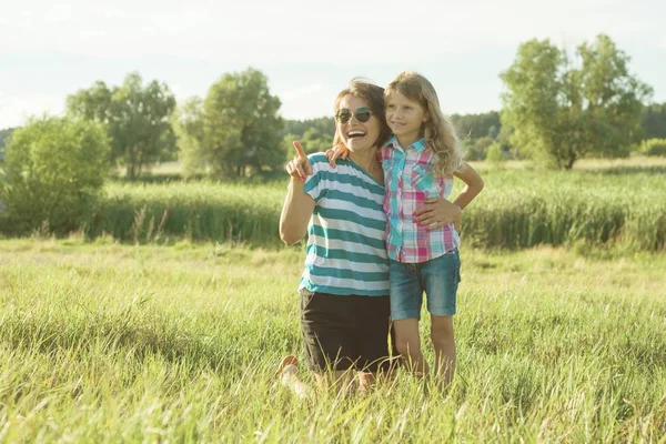 Glada vuxna mamma leker utomhus med hennes dotter barn flicka. Bakgrunden natur, sommar — Stockfoto