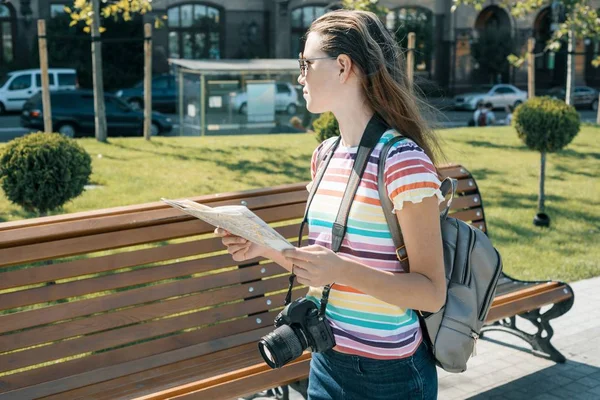 Junge lächelnde Studentin mit Stadtplan und Kamera, weiblich unterwegs an einem sonnigen Sommertag — Stockfoto