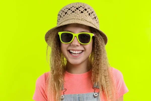 Retrato de verano de adolescente sonriente en gafas de sol sombrero de paja sobre fondo de estudio amarillo — Foto de Stock