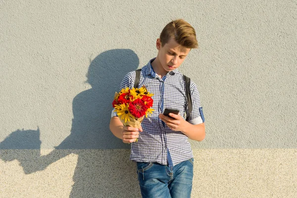 Retrato al aire libre de adolescente con ramo de flores, fondo de pared gris, espacio para copiar — Foto de Stock