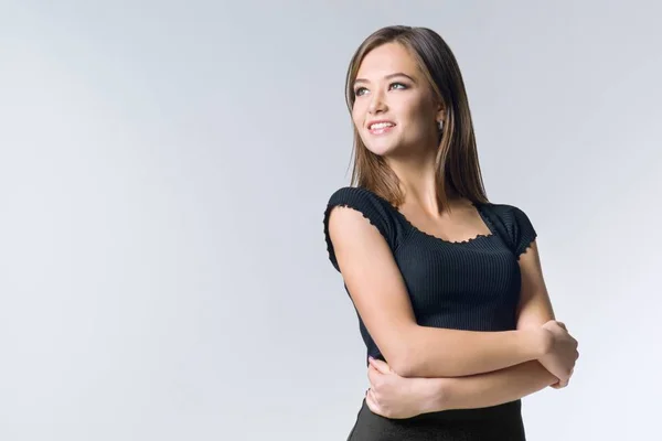 Portrait of young attractive smiling girl with crossed arms, on white background, copy space Stock Image