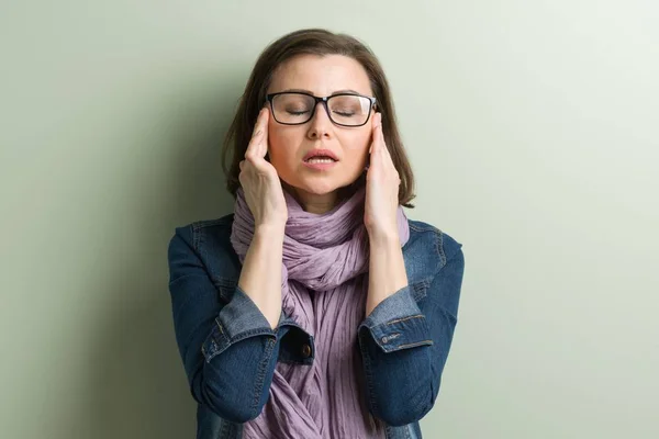 Mujer madura sosteniendo sus manos con la cabeza, depresión problemas de dolor de cabeza migraña — Foto de Stock