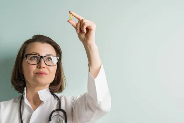 Female doctor with vitamin capsule. Healthy lifestyle, nutritional supplements, vitamin d, e, fish oil capsules. — Stock Photo, Image