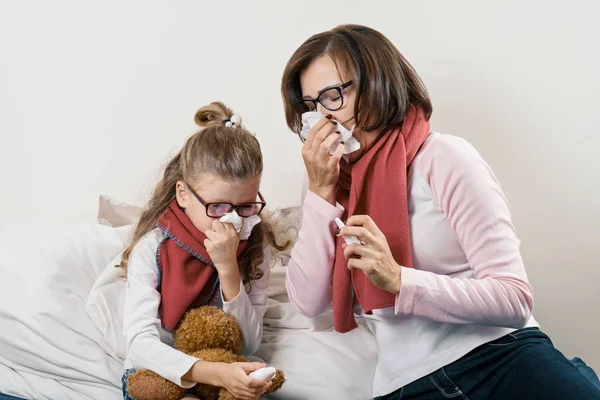 Malade mère et enfant éternuant dans le mouchoir, tenant pulvérisation nasale, saison froide — Photo