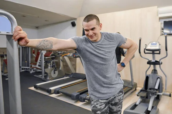 Porträt eines jungen, lächelnden, muskulösen Mannes im Fitnessstudio — Stockfoto