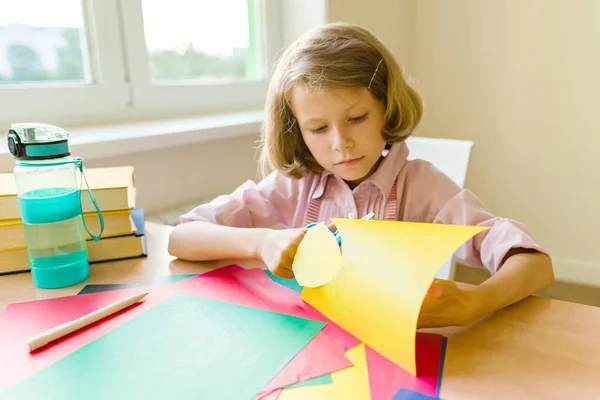 女性の子供は、窓の近くのテーブルで自宅に座って、紙をはさみ、創造性を作ります。学校, 教育, 知識と子供. — ストック写真
