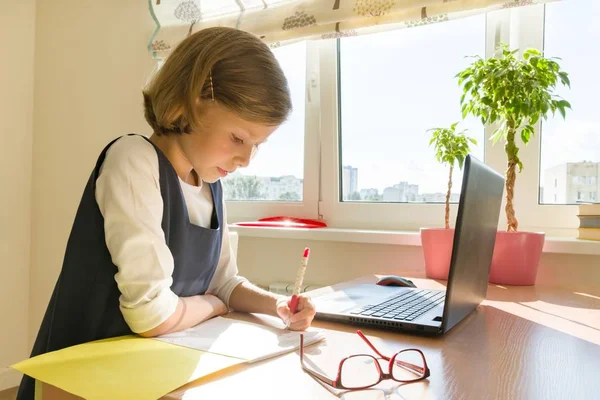 Kleine meisje student studeert vergadering op haar bureau, meisje schrijft in notitieblok voor leerling. School, onderwijs, kennis en kinderen — Stockfoto