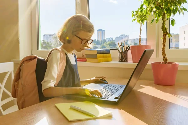 Giovane hacker bambina in occhiali con uno zaino della scuola che lavora al computer, laptop — Foto Stock