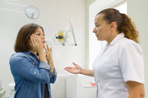 Взрослая женщина, страдающая зубной болью и жалующаяся во время посещения профессионального стоматолога . — стоковое фото