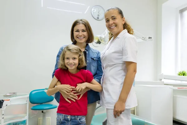 Porträtt av en lycklig mor med barn och läkare tandläkare, i tandläkar mottagning. — Stockfoto