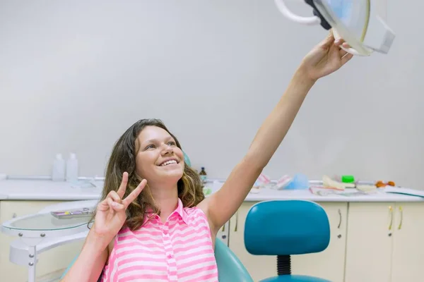 Щаслива дівчина-підліток у стоматологічному кріслі. Медицина, стоматологія та концепція охорони здоров'я — стокове фото
