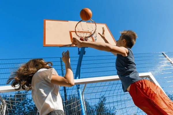 ストリート ボール バスケット ボール ゲーム 2 人のプレーヤー、ティーンエイ ジャーの女の子とボール、屋外市バスケット ボール裁判所で少年. — ストック写真
