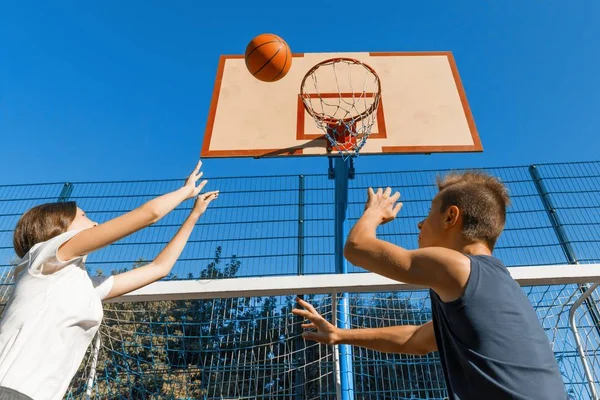 ストリート ボール バスケット ボール ゲーム 2 人のプレーヤー、ティーンエイ ジャーの女の子とボール、屋外市バスケット ボール裁判所で少年. — ストック写真
