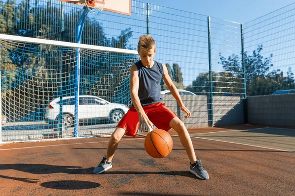 Caucásico adolescente niño calle baloncesto jugador con pelota en al aire libre ciudad baloncesto cancha — Foto de Stock