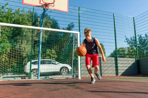 Відкритий портрет вуличного баскетболіста, який грає з м'ячем в сонячний день — стокове фото