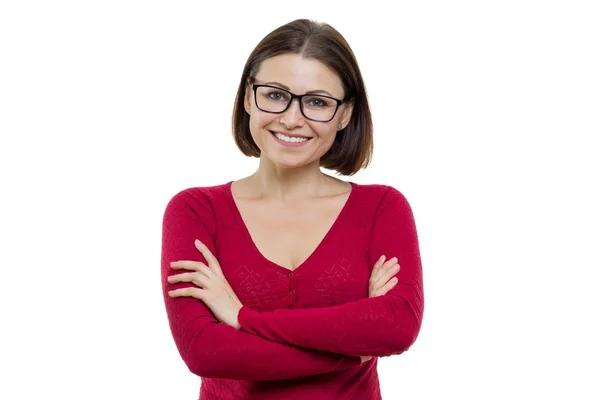 Улыбающаяся успешная уверенная женщина среднего возраста в очках со сложенными руками, смотрящая на камеру на белом фоне, изолированная — стоковое фото