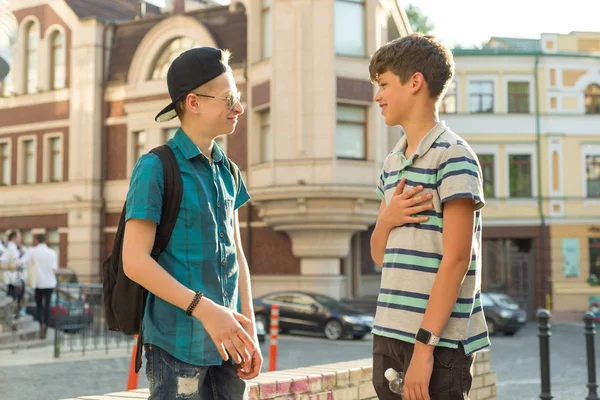 A barátság és a kommunikáció két tizenéves fiúk az 13, 14 éves, a város utcai háttér — Stock Fotó