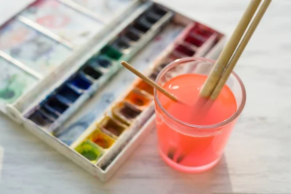 Pincéis e tintas de aquarela profissionais na borda da janela branca de madeira — Fotografia de Stock