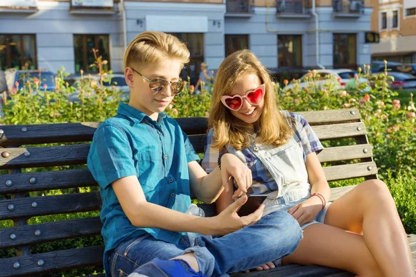 Teenager-Freunde Mädchen und Junge sitzen auf Bank in der Stadt und unterhalten sich. Freundschaft und Menschen — Stockfoto