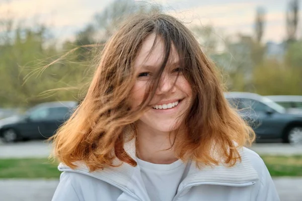Portrait extérieur d'une adolescente de 15 ans, fille souriante aux longs cheveux bruns en veste blanche — Photo