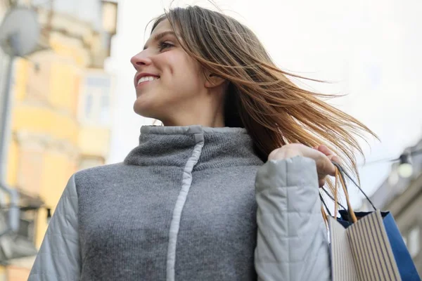 Outdoor portrait of young beautiful smiling woman with shopping bags closeup, spring shopping — Stock Photo, Image