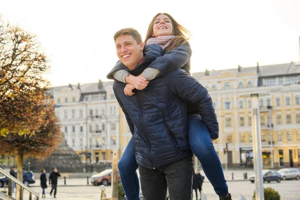 Par vackra studenter har roligt i staden, bakgrund vårstad, ung man och kvinna skrattar, gyllene timmen — Stockfoto