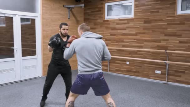 Dwa młode męskie bokserki trenują na siłowni. Kijów UA, 28-03-2019. — Wideo stockowe