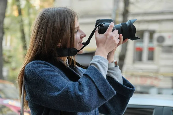 Szép fiatal nő kamerával a városban. Turista lány utazás és fényképezés, tavaszi városi utcai háttér — Stock Fotó
