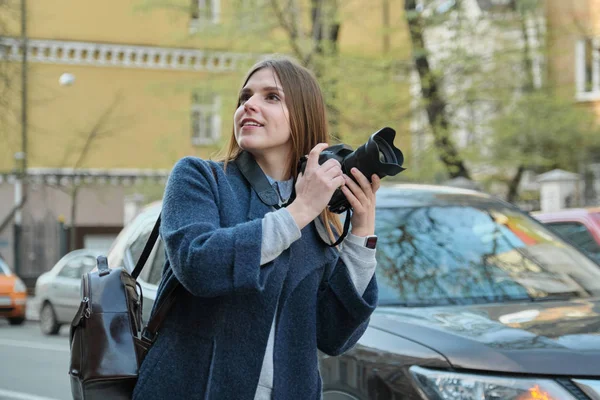 Junges schönes Mädchen mit Kamera in der Frühlingsstadt, Touristin fotografiert auf der Straße der Stadt — Stockfoto