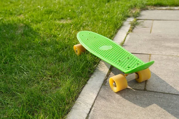 Teenage skateboard sur pavés gris et herbe verte — Photo
