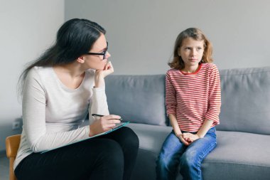 Profesyonel çocuk psikoloğu ofiste çocuk kız ile konuşuyor